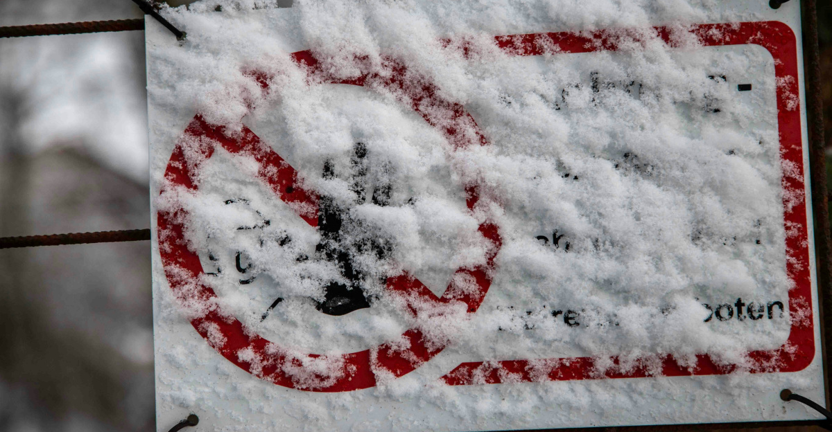 Sign covered in snow with a red circle and line.