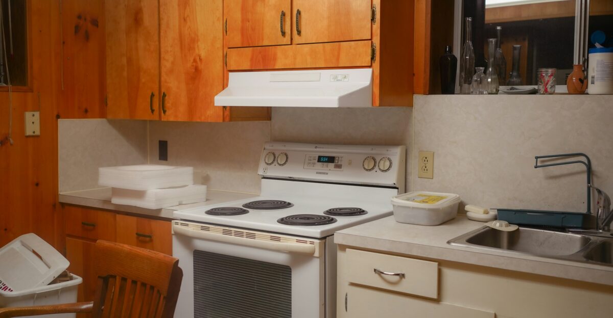 A simple kitchen with wooden cabinets and white appliances