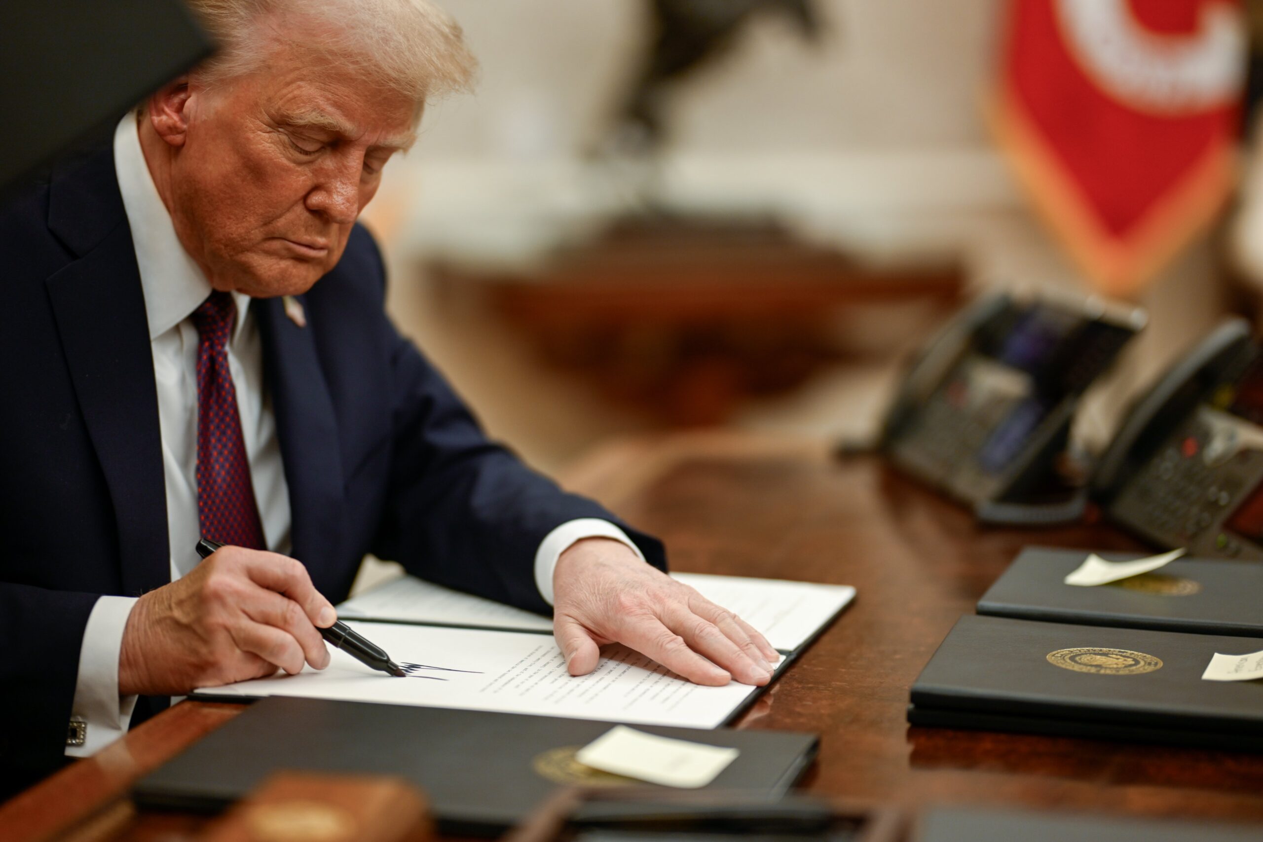 Trump signing an executive order on the first day of his second term in office