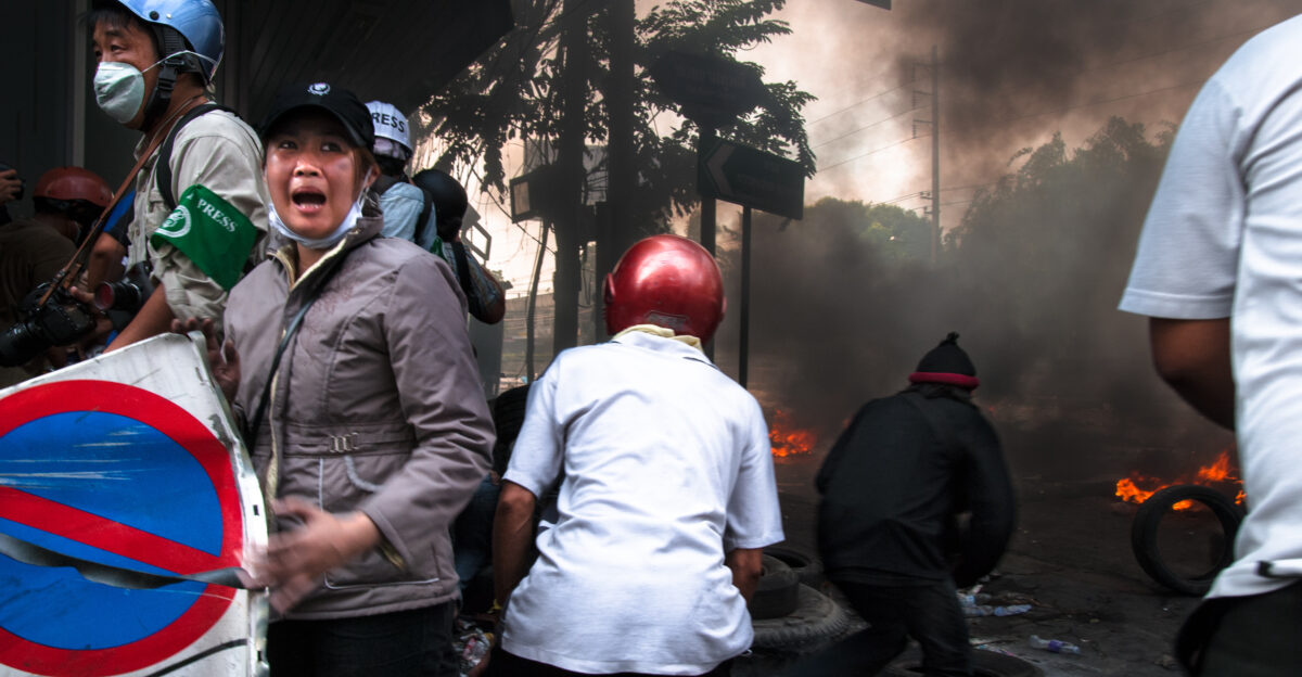 A woman cries as there are still wounded men lying out on Rama 4 The army continues to shoot at the location where they are lying even after people including Thai journalists and rescue workers have asked them to stop One hardcore red shirt boy runs out to aid the wounded