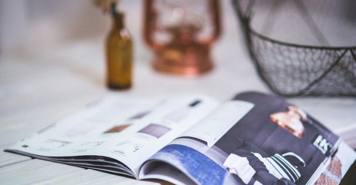 A stylish open magazine on a minimalistic desk with a blurred background