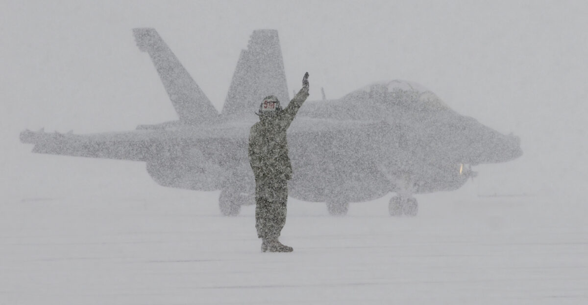 NAVAL AIR FACILITY MISAWA Japan Jan 10 2013 A ground crew member from Electronic Attack Squadron VAQ 132 signals to an EA-18G Growler as it returns from a flight during heavy snows at Naval Air Facility Misawa VAQ-132 is finishing up a six-month deployment in support of U S 7th Fleet U S Navy photo by Mass Communication Specialist 1st Class Kenneth G Takada Released 130110-N-VZ328-444 Join the conversation navylive dodlive mil
