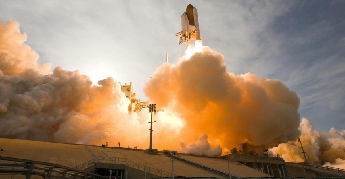 Dramatic view of a space shuttle launching surrounded by smoke and fire