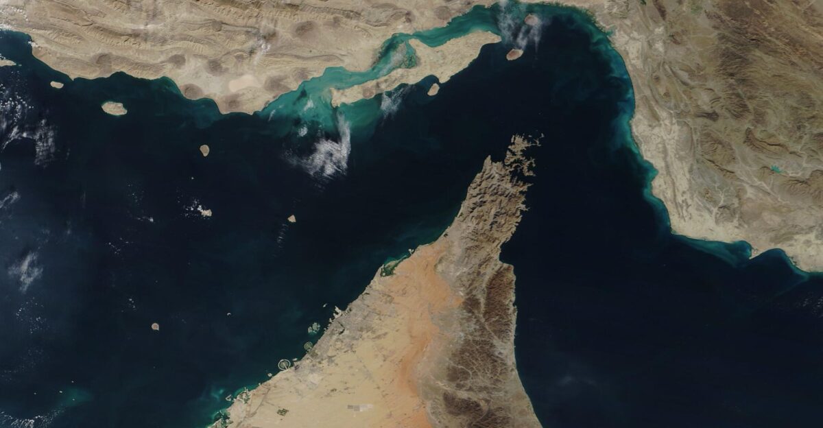 The narrow Strait of Hormuz lies between the Persian Gulf and the Gulf of Oman separating Iran north from the Arabian Peninsula south Only about 21 miles 34 km wide at the narrowest point and roughly 96 miles 155 km long about thirty percent of the world s seaborne oil and nearly one-quarter of the liquified natural gas LNG supply passes through this strait - all on shipping lanes that measure only two-mile wide It has been estimated that 21 million barrels of oil with a value of 1 2 billion US dollars USD pass through the strait every day On December 2 2020 the Moderate Resolution Imaging Spectroradiometer MODIS on board NASA s Terra satellite acquired a true-color image of the Strait of Hormuz The arid landscape of Iran sits in the north with Qeshm Island the largest in the Persian Gulf just off the Iranian coast The tiny Strait of Khuran separates the island and the mainland and bounds a wetland of international importance recognized by Ramsar These wetlands provide critical habitat to two globally threatened species the Dalmatian Pelican and the Green sea turtle In the south the rocky and rugged Musandam Peninsula juts into the Strait of Hormuz The tip of the peninsula is filled by the Musandam Governate an exclave of Oman To the south the land on the peninsula belongs to the United Arab Emirates
