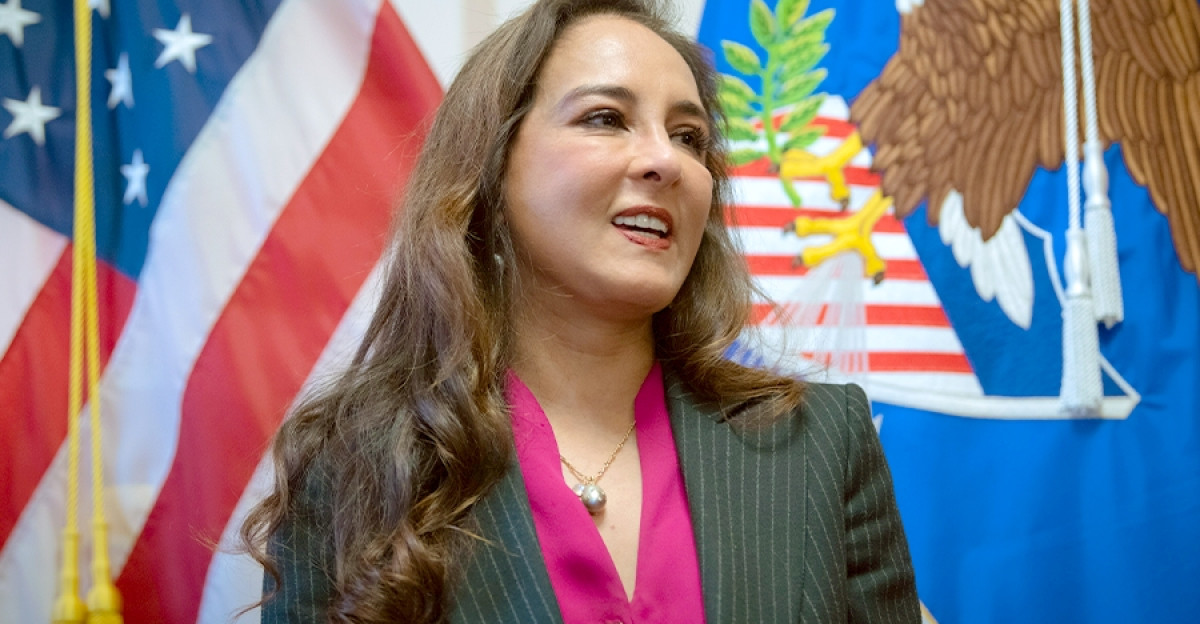 Pictured The newly appointed Assistant Attorney General for the Civil Rights Division Harmeet Dhillon stands in front of the American flag left and the Department of Justice flag right