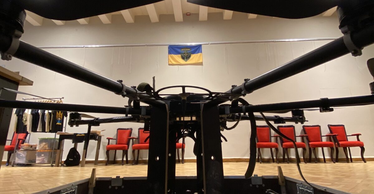 R18 drone on the exhibition at the show of the Sky Coordinator film in honor of Volodymyr Kochetkov-Sukach Organized by Aerorozvidka The Aerorozvidka flag hangs on the wall