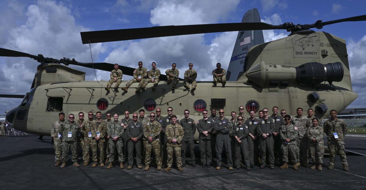 U S military members take a group photo in front of a CH-47 Chinook assigned to the 214th Aviation Regiment 12th Combat Aviation Brigade during Farnborough International Airshow in Farnborough England July 26 2024 FIA is another opportunity for the U S military to come together with U K and NATO Allies and partners to display the dynamic capabilities of various aircraft and highlight collective readiness U S Air Force photo by Senior Airman Katie Mullikin