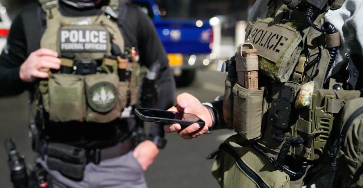 Two federal law enforcement officers coordinate with other officials on the ground during an enhanced immigration enforcement operation near Washington D C in the early morning hours of Feb 4