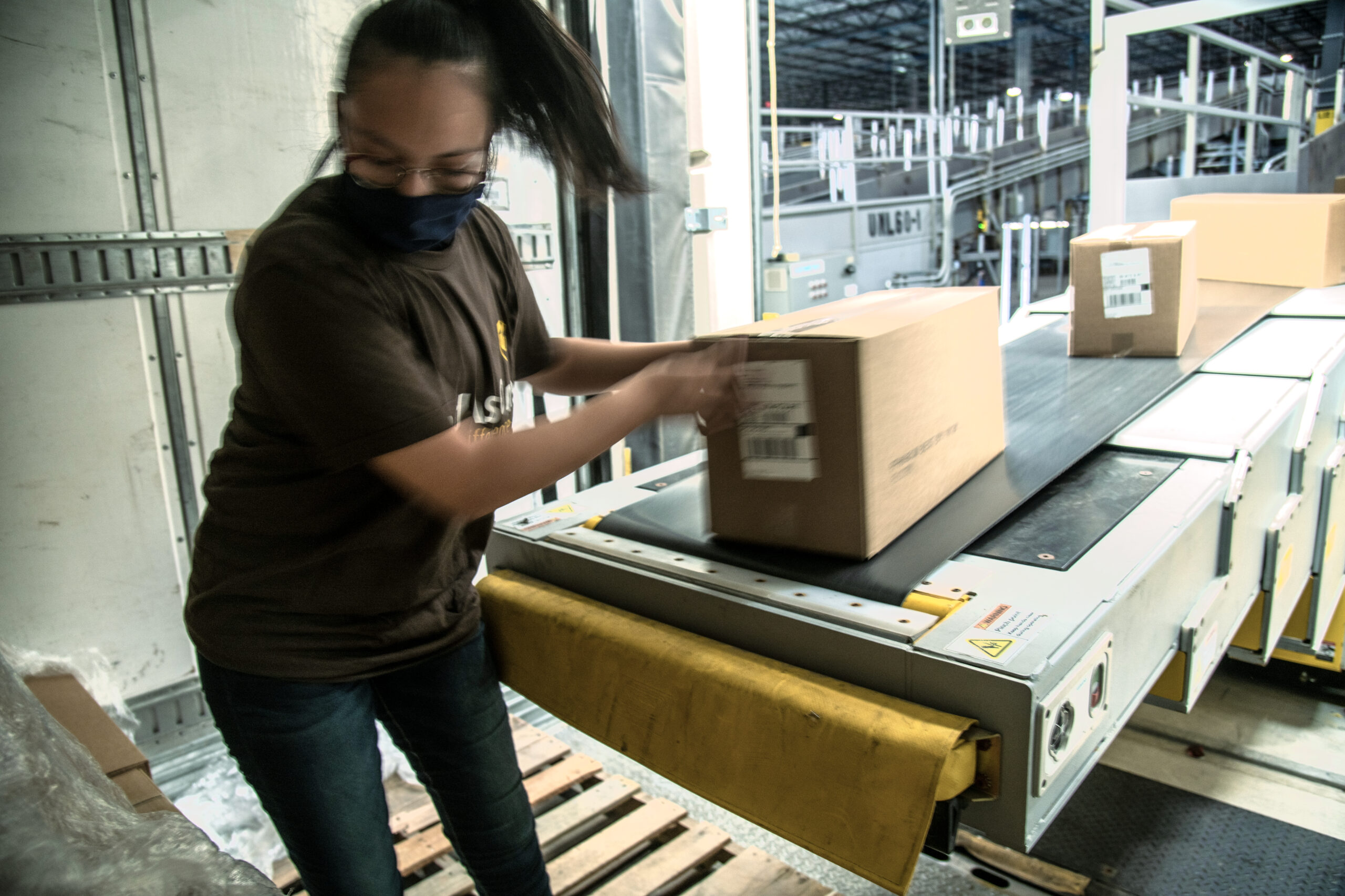 UPS employee Jocelin Zuniga unloads food boxes at the more than 1 million-square-foot UPS Lone Star distribution center hub in Arlington TX on August 14 2020 These boxes from nearby Pro Pac Quality Packaging were packed and labeled for PepsiCo who partnered with U S Department of Agriculture USDA Food and Nutrition Service FNS Meals to You program in responded to the school closures due to COVID-19 Packages will ride on this extendable conveyor system and join other packages in the automated system of conveyors chutes sensors sorters and staging systems that will transport them to their best outbound trailer to their next hub or delivery center UPS and other package delivery services are utilized by PepsiCo and other partners to implemented a logistics solution that get two-week supplemental food boxes to children in rural locations Today s packages are heading to rural Texas Puerto Rico and Alaska The program includes 41 States and two territories USDA first began the Meals to You program in 2019 as a three-year demonstration project designed to test a method to deliver nutritious food to children during the summer months in rural areas where the Summer Food Service Program SFSP is not available to difficult to access USDA entered into an agreement with Baylor University s Texas Hunger Initiative now called the Baylor Collaborative on Hunger and Poverty for the original demonstration In response to COVID-19 USDA and its partners were able to leverage the summer demonstration project to ensure rural children had access to food during pandemic-related school closures The Emergency Meals to You demonstration project continues our public-private partnership with the Baylor Collaborative on Hunger and Poverty and McLane Global that began in Summer 2019 and additionally includes Pepsi Co and Chartwells USDA was able to fund this expansion utilizing funding provided by the CARES Act Overall we allocated 185 million for the program from the 8 8 billion that the CARES Act provided for Child Nutrition Meals to You boxes are delivered directly to children s homes via the U S Postal Service or another delivery service Each box contains 20 nutritious shelf-stable meals including ten breakfasts and ten lunches suppers In participating states families with students who attend an eligible school or are eligible for free or reduced-price meals may opt-in to receive one box per child every two weeks The original goal was to serve 1 million meals per week which was quickly surpassed The partnership is now serving around 5 million meals per week For more information about the 1 000 000 meals a week program partnership please visit usda gov media press-releases 2020 03 17 usda-announces-feeding-program-partnership-response-covid-19 For more information about FNS Program Guidance on Human Pandemic Response please visit fns usda gov disaster pandemic For additional information and photos please visit the album and see its description flic kr s aHsmPrXwEi flic kr s aHsmMdK2x3 USDA Media by Lance Cheung Photographs of a commercial product or enterprise do not constitute an endorsement by the USDA over products or enterprises not shown
