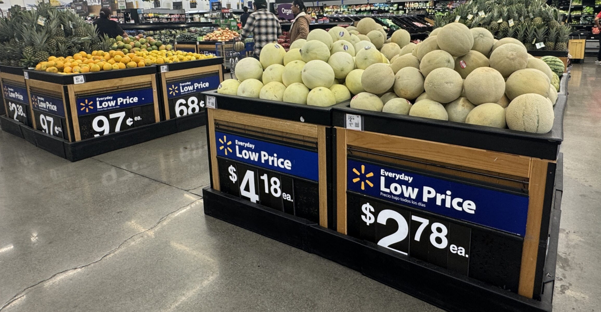 Produce section of a Walmart store with bins of melons, pineapples, and other fruit under “Everyday Low Price” signs. Napa, California.