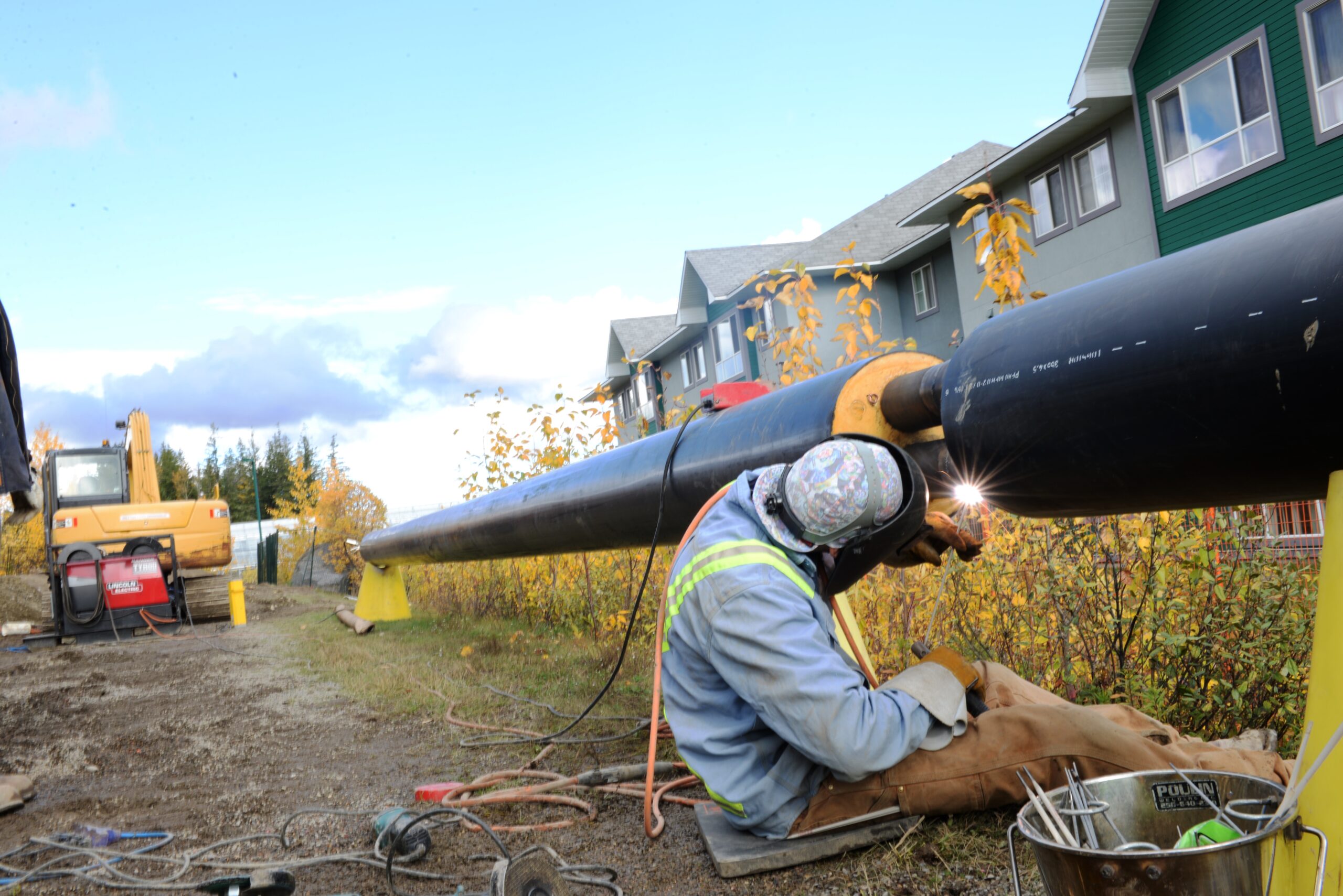 A welder welding pipe on UNBC campus Prince George BC Canada