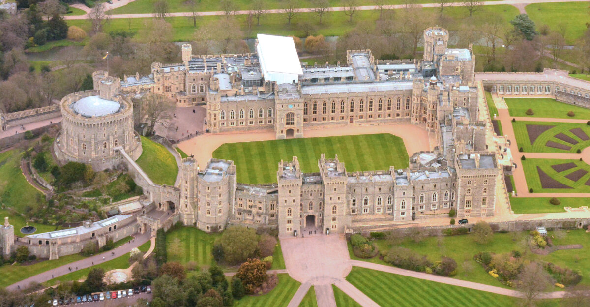 One of the places the Queen lives in when outside London It s located to the West of London not far from Heathrow Airport It s the location of the wedding of Prince Harry Henry to Meghan Markle on 19 May 2018 Windsor Castle is the oldest and largest inhabited castle in the world and has been the family home of British kings and queens for almost 1 000 years It is an official residence of Her Majesty The Queen and is still very much a working royal palace today home to around 150 people If you zoom in and look at the entrance you may - just - be able to see a Royal Guard marching from one side to the other past 3 other people standing there On the Round Tower at the left I think I see the Royal Standard flying - the Queen s personal flag which would indicate that when I took the picture she was in residence at the castle
