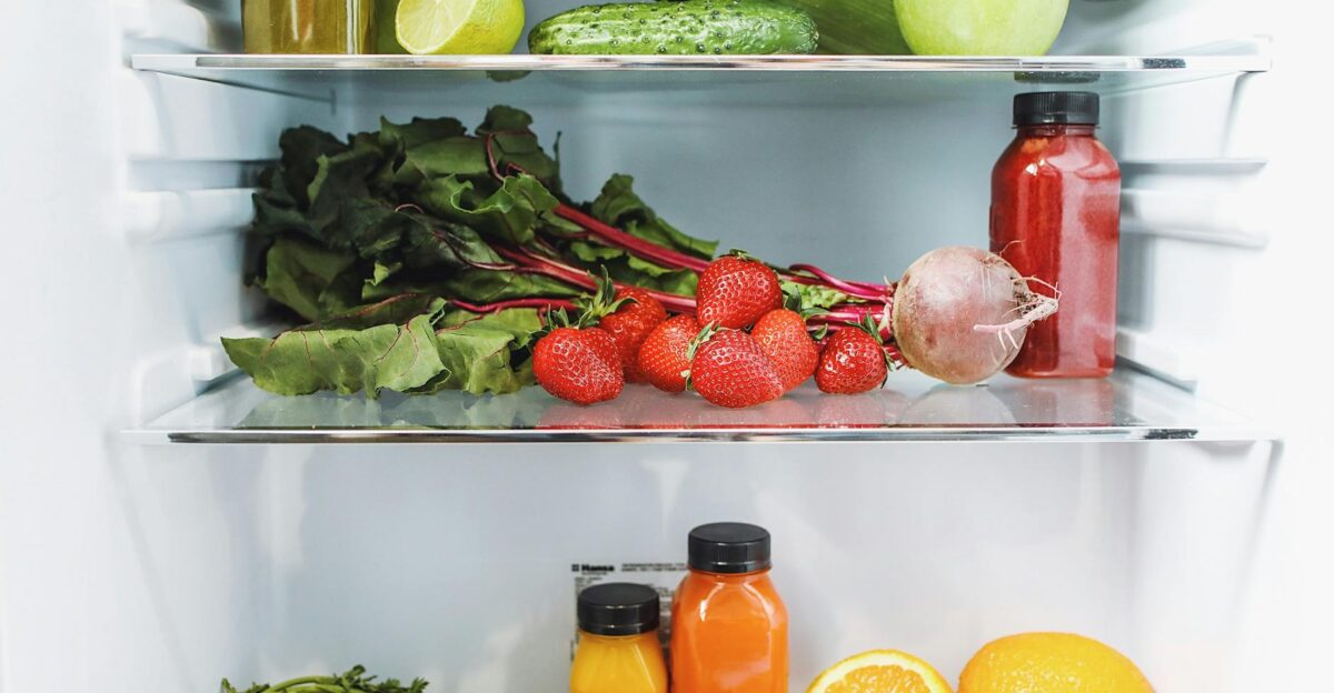 Colorful array of fresh fruits and vegetables neatly arranged in a refrigerator