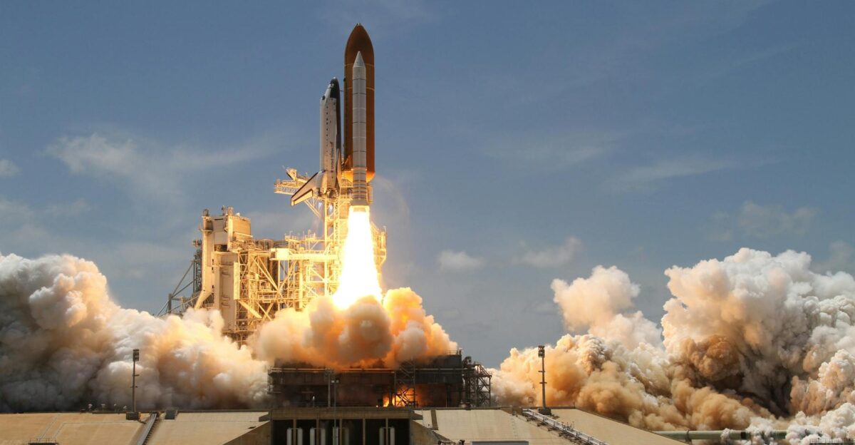 A NASA space shuttle launches with fiery liftoff ascending into the sky amid plumes of smoke