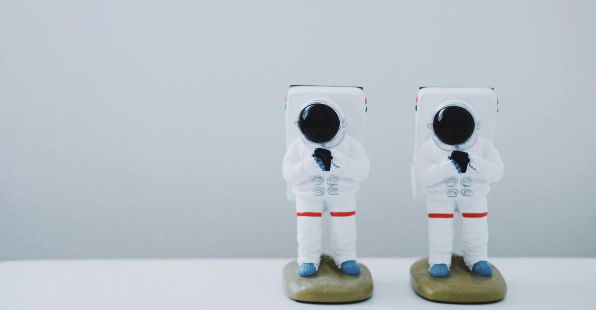 two spacesuit figurines on white surface